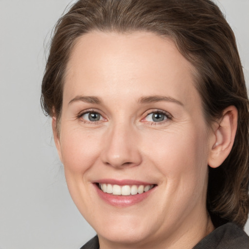 Joyful white adult female with medium  brown hair and grey eyes