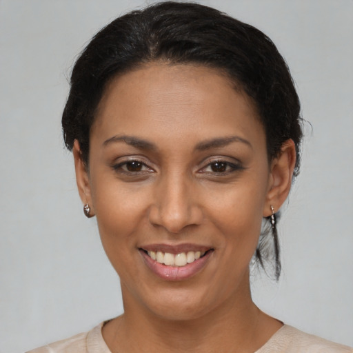 Joyful black young-adult female with short  brown hair and brown eyes