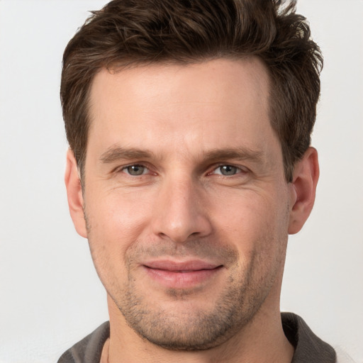 Joyful white adult male with short  brown hair and brown eyes