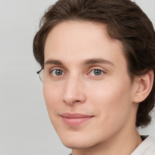 Joyful white young-adult male with medium  brown hair and grey eyes