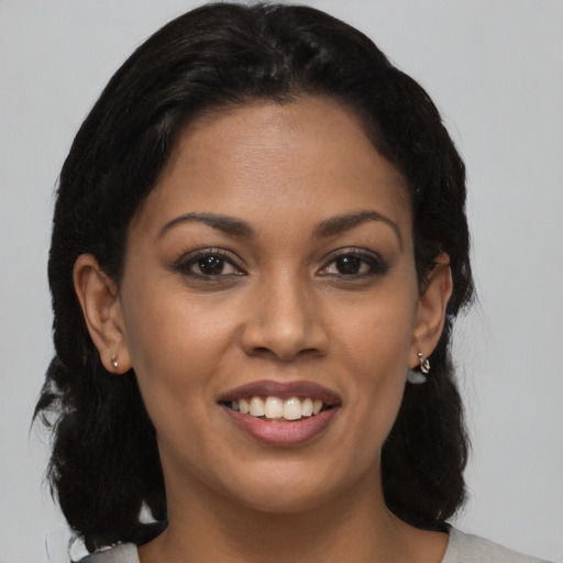 Joyful black young-adult female with medium  brown hair and brown eyes