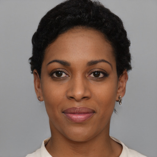 Joyful black young-adult female with short  black hair and brown eyes