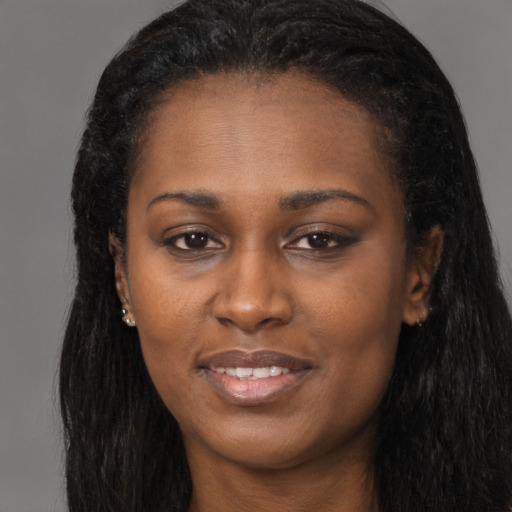 Joyful black young-adult female with long  black hair and brown eyes