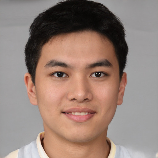 Joyful asian young-adult male with short  brown hair and brown eyes