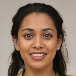 Joyful latino young-adult female with medium  brown hair and brown eyes