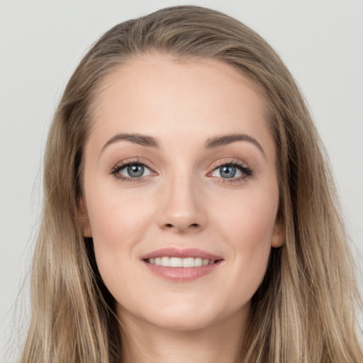 Joyful white young-adult female with long  brown hair and grey eyes