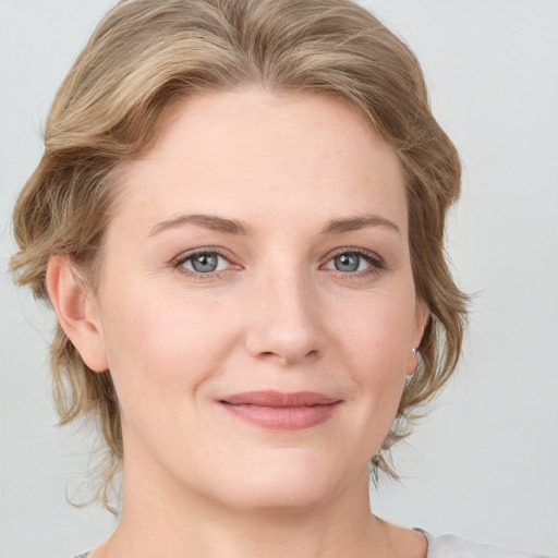 Joyful white young-adult female with medium  brown hair and blue eyes