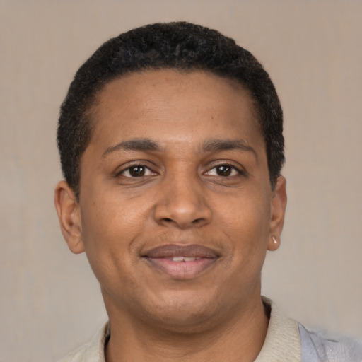 Joyful black young-adult male with short  brown hair and brown eyes