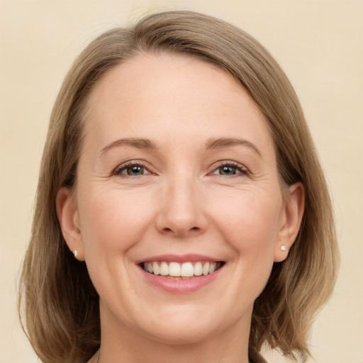 Joyful white adult female with medium  brown hair and grey eyes