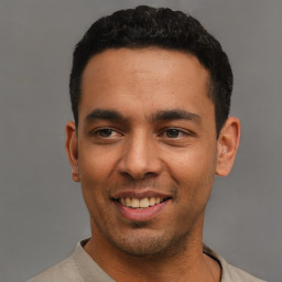 Joyful latino young-adult male with short  black hair and brown eyes