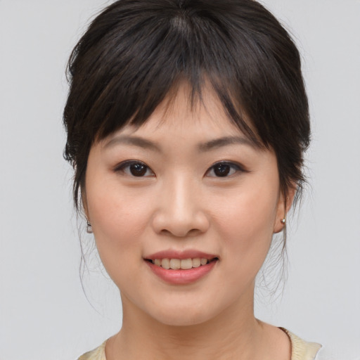 Joyful asian young-adult female with medium  brown hair and brown eyes