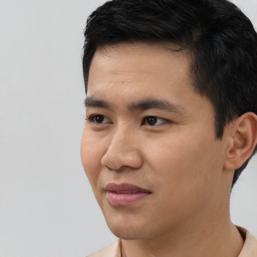 Joyful asian young-adult male with short  black hair and brown eyes