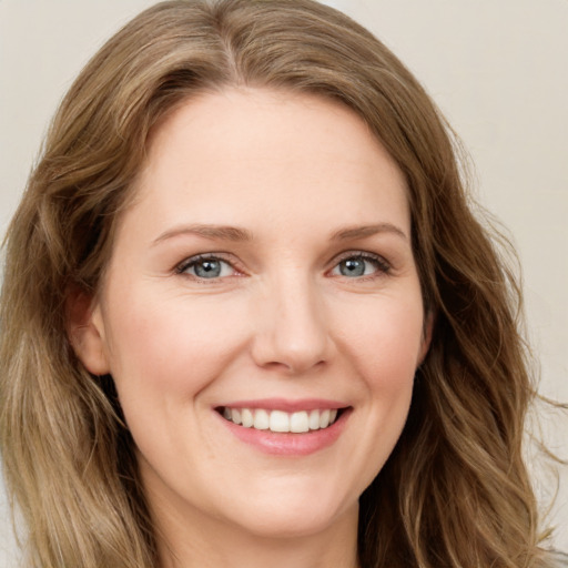 Joyful white young-adult female with long  brown hair and green eyes