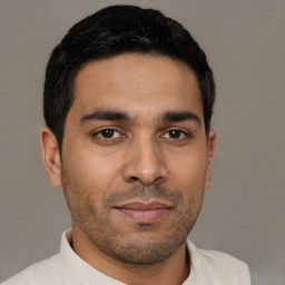 Joyful latino young-adult male with short  black hair and brown eyes