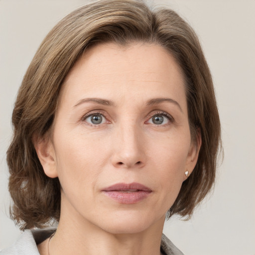 Joyful white adult female with medium  brown hair and grey eyes