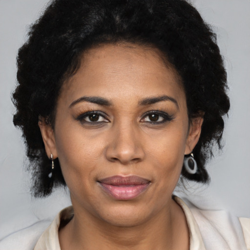 Joyful latino adult female with medium  black hair and brown eyes