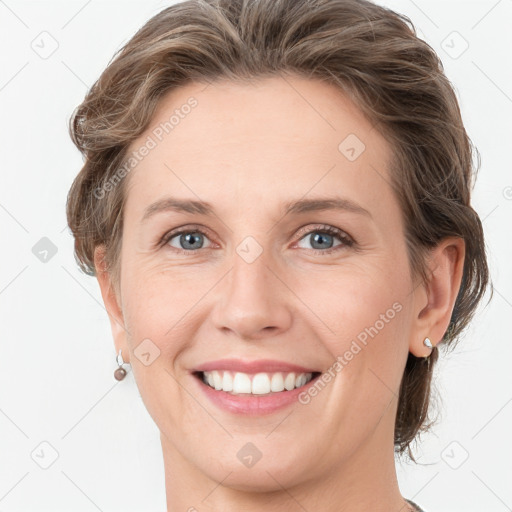 Joyful white young-adult female with medium  brown hair and grey eyes