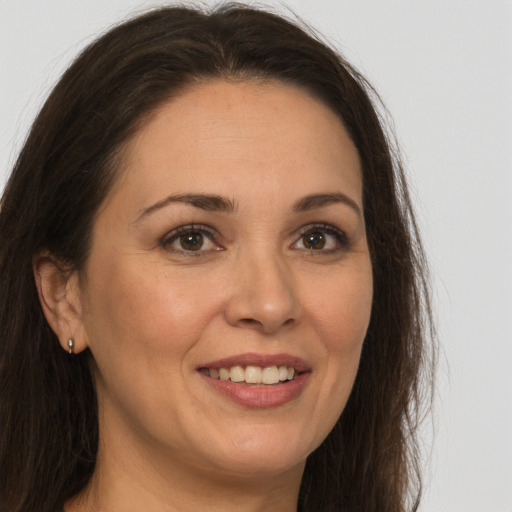 Joyful white adult female with long  brown hair and brown eyes