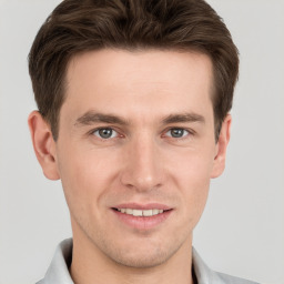 Joyful white young-adult male with short  brown hair and grey eyes