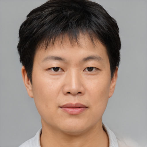 Joyful asian young-adult male with short  brown hair and brown eyes