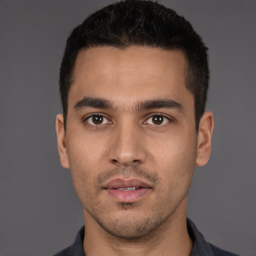 Joyful white young-adult male with short  black hair and brown eyes