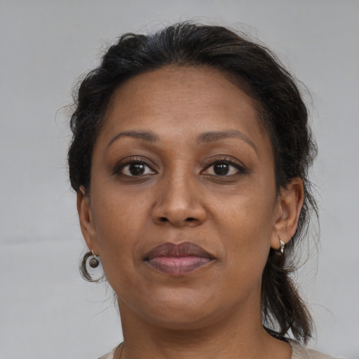 Joyful black adult female with medium  brown hair and brown eyes