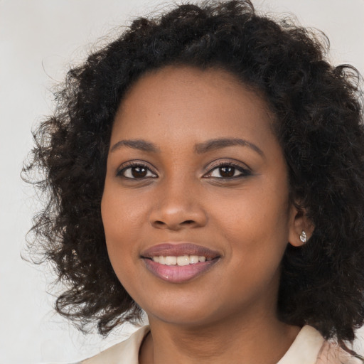 Joyful black young-adult female with long  brown hair and brown eyes