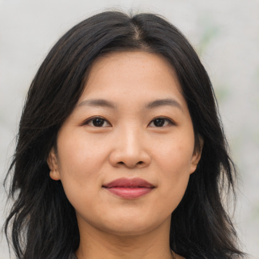 Joyful asian young-adult female with long  brown hair and brown eyes