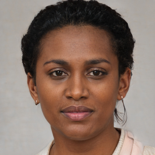 Joyful black young-adult female with short  black hair and brown eyes