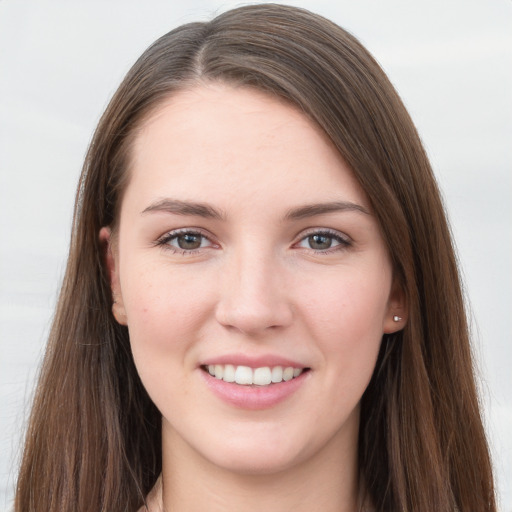 Joyful white young-adult female with long  brown hair and grey eyes