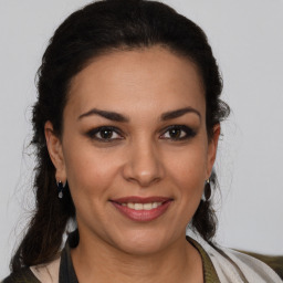 Joyful latino young-adult female with medium  brown hair and brown eyes