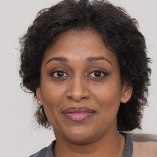 Joyful black adult female with medium  brown hair and brown eyes