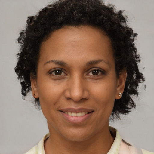 Joyful black adult female with short  brown hair and brown eyes