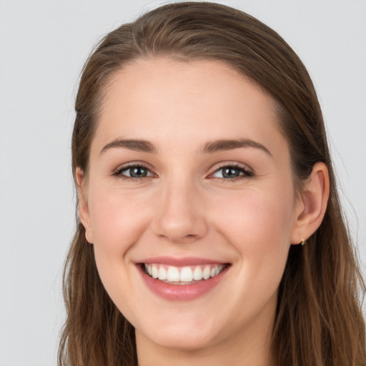 Joyful white young-adult female with long  brown hair and grey eyes