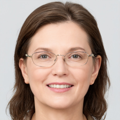 Joyful white adult female with medium  brown hair and grey eyes