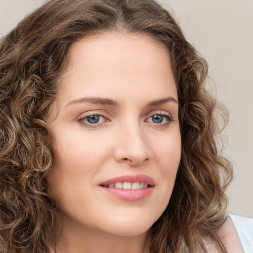 Joyful white young-adult female with long  brown hair and green eyes