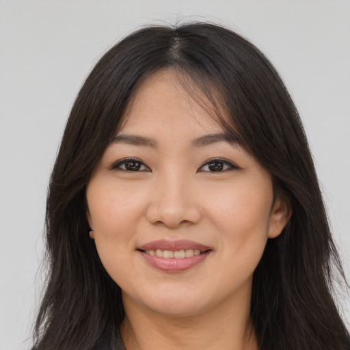 Joyful asian young-adult female with long  brown hair and brown eyes
