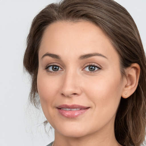 Joyful white young-adult female with long  brown hair and grey eyes