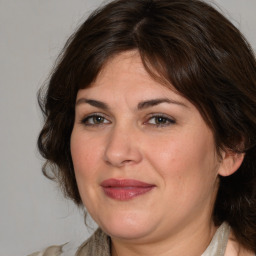 Joyful white adult female with medium  brown hair and brown eyes