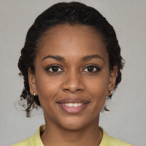 Joyful black young-adult female with short  brown hair and brown eyes