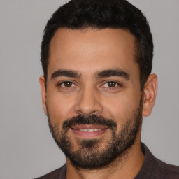 Joyful latino young-adult male with short  black hair and brown eyes