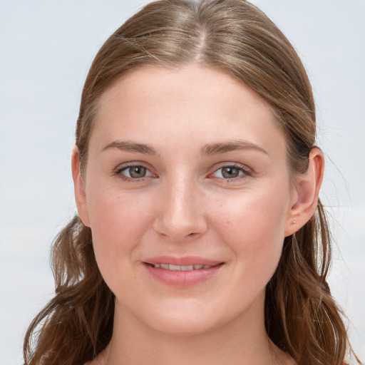 Joyful white young-adult female with long  brown hair and blue eyes