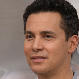 Joyful white adult male with short  black hair and brown eyes