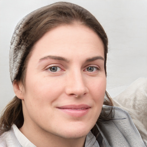 Joyful white young-adult female with medium  brown hair and grey eyes