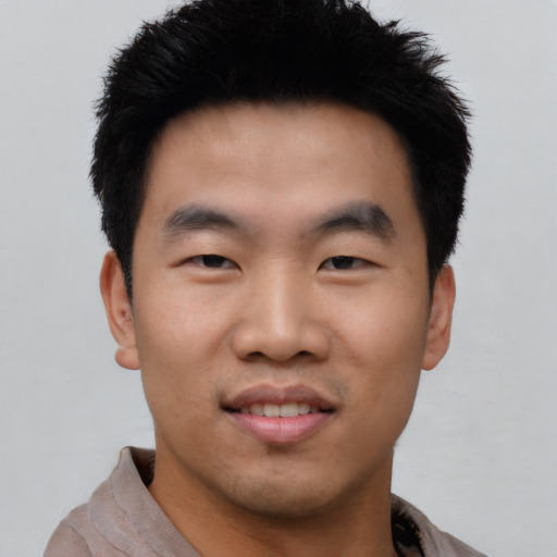 Joyful asian young-adult male with short  black hair and brown eyes