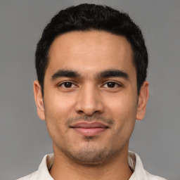 Joyful latino young-adult male with short  black hair and brown eyes