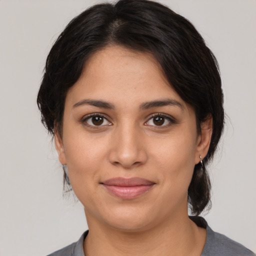 Joyful latino young-adult female with medium  brown hair and brown eyes