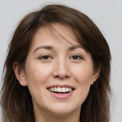 Joyful white young-adult female with long  brown hair and brown eyes