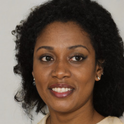 Joyful black young-adult female with medium  brown hair and brown eyes