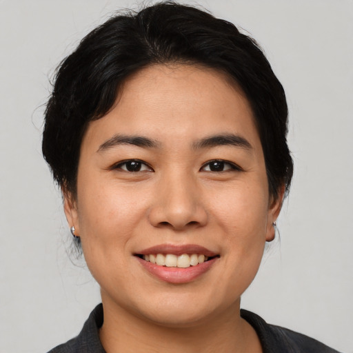 Joyful asian young-adult female with medium  black hair and brown eyes